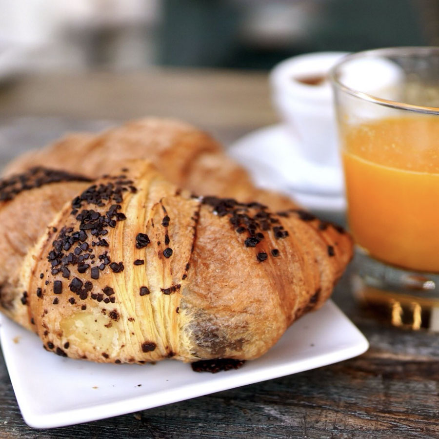 Luca e Andrea colazione con brioche al cioccolato, bicchiere di spremuta e un buon caffè per iniziare al meglio la giornata